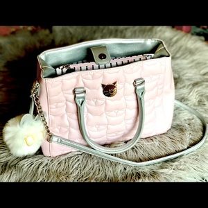 Might as well be new, pink Betsey Johnson’s signature kitty embossed handbag.